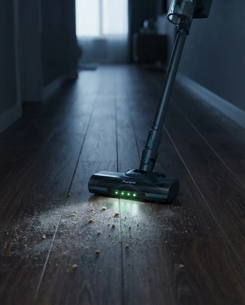 Puravo Stick sweeping a dark hallway floor with its green LED strip lighting the dust ahead