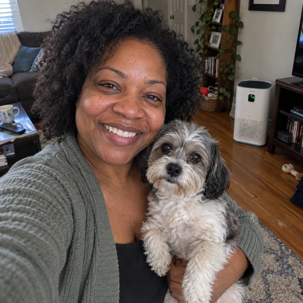 Renee holding her dog in the living room, the Puravo Air behind her